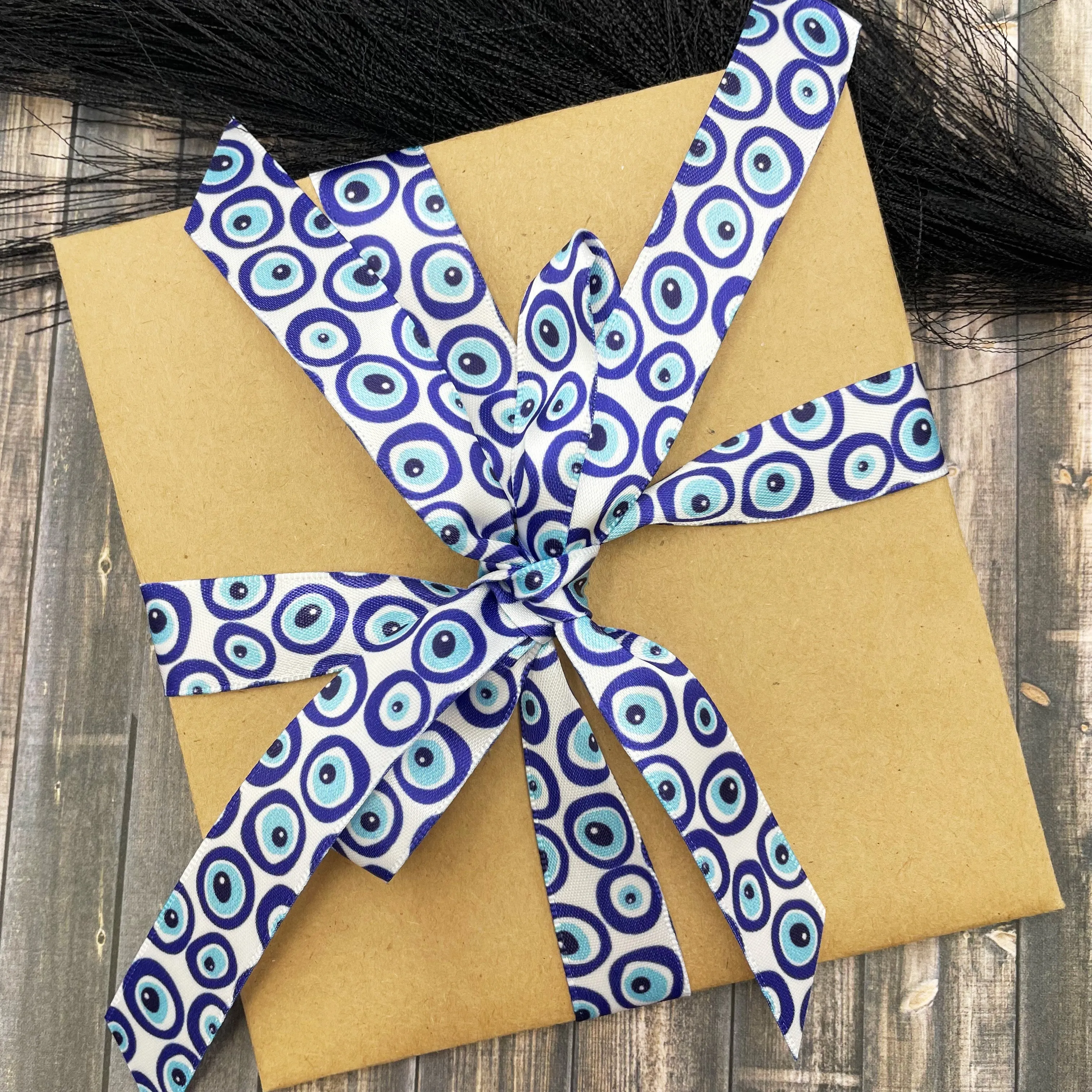 Evil eye ribbon in blue and white printed on 5/8" white single face satin